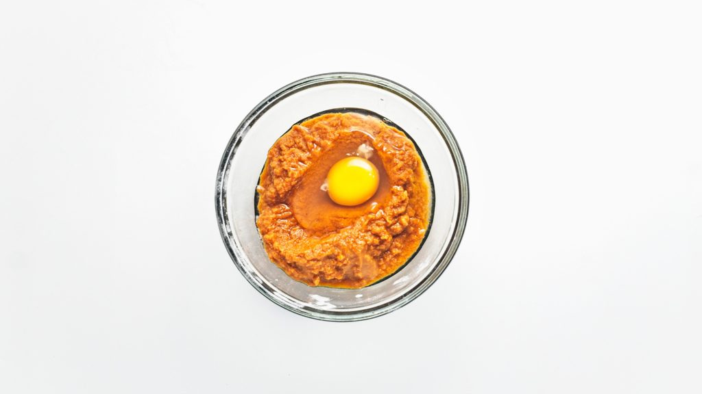 Pumpkin Getting Mixed With Egg in Glass Bowl